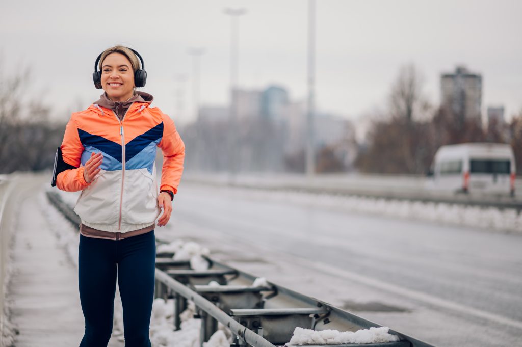 Frau läuft auf der Brücke bei Winter und Schnee.